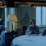 Maître d’ presenting luxury menu cover in grand dining room