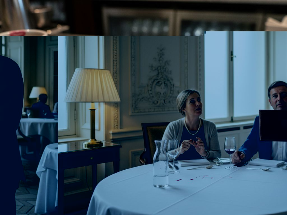 Maître d’ presenting luxury menu cover in grand dining room