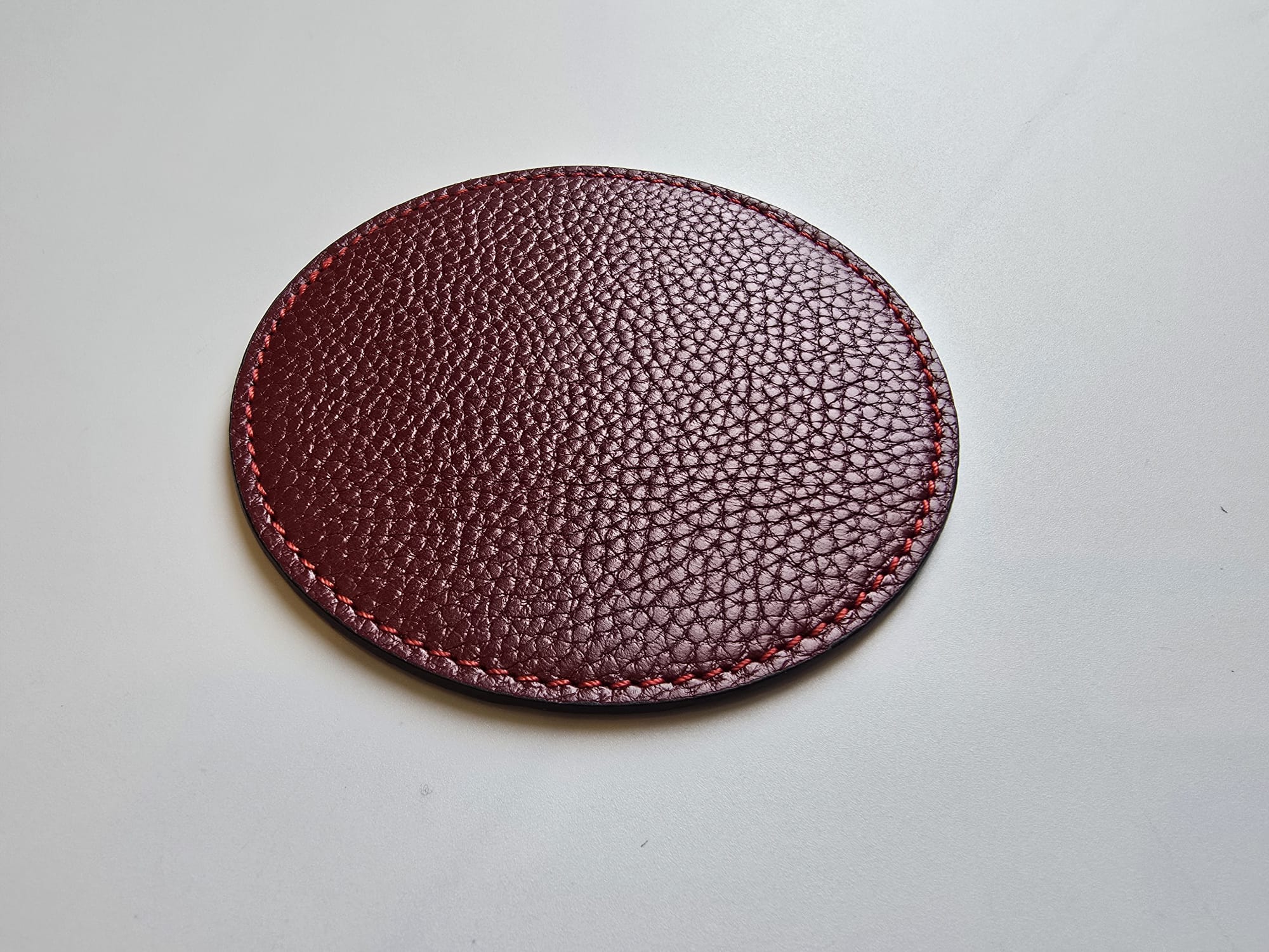 Burgundy leather coaster closeup detail